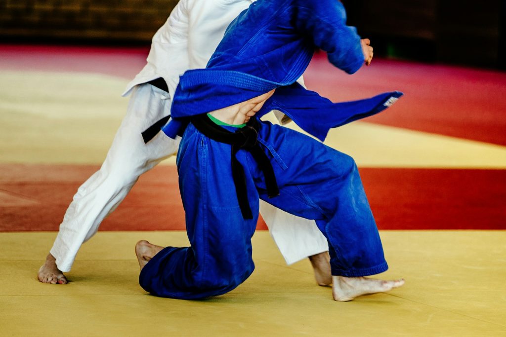 deux hommes lutteurs judoka kimono blanc et bleu sur combat tatami