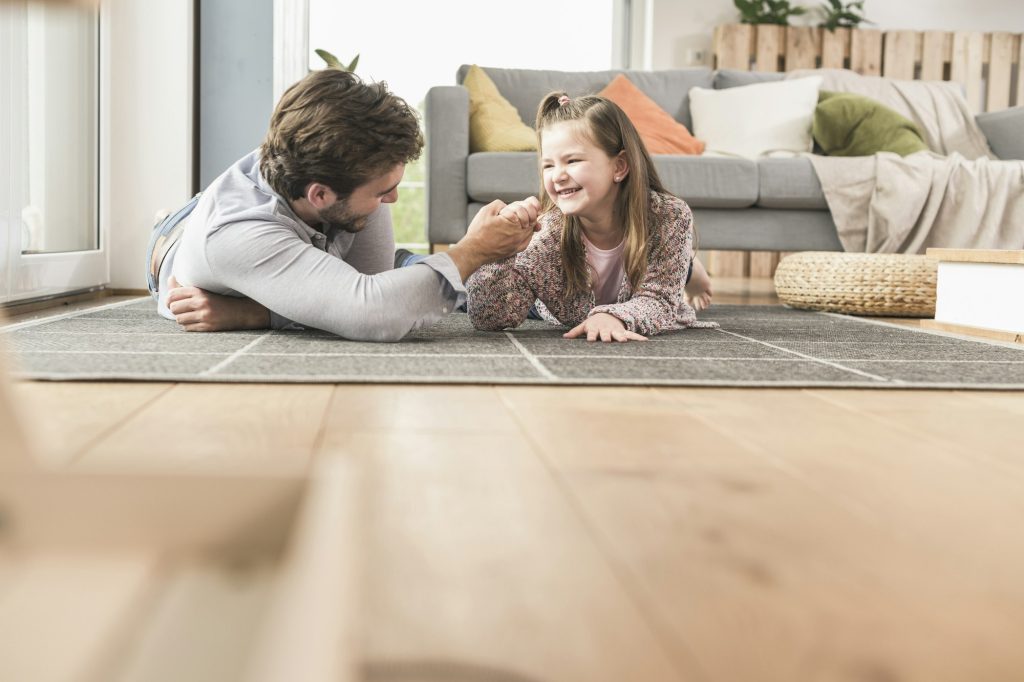 Jeune homme et petite fille allongée sur le sol, bras de fer