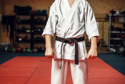 Arts martiaux, jeune combattant en kimono blanc et ceinture noire en séance d'entraînement en salle de sport