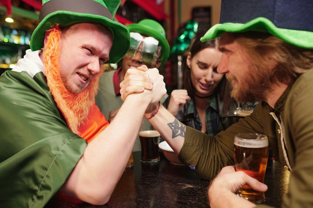 Un jeune homme se tient la main et s'affronte lors d'un match de bras de fer à une table dans un bar