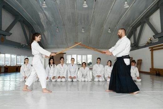 Maître d'arts martiaux enseignant aux jeunes étudiants à se battre avec une épée en bois.