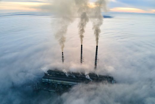 Tuyaux hauts de centrale à charbon avec de la fumée noire se déplaçant vers le haut, une atmosphère polluante.