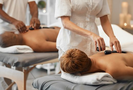 Massage aux pierres chaudes, couple noir et spa relaxant dans les soins de la peau, les soins de santé ou la gestion du stress.