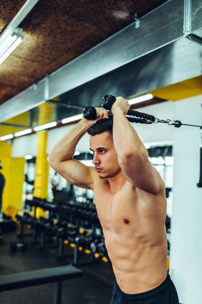 Jeune homme travaillant à la salle de sport