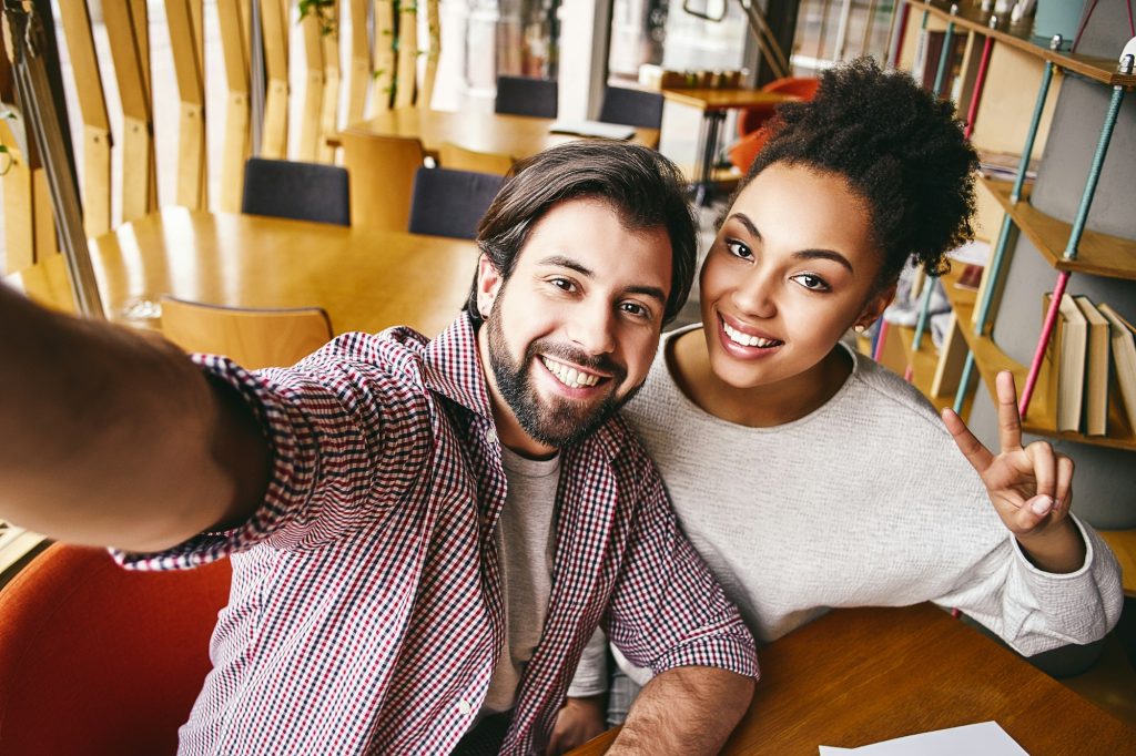 Deux jeunes hommes d'affaires rieurs en tenue décontractée sourient pour se prendre en photo.